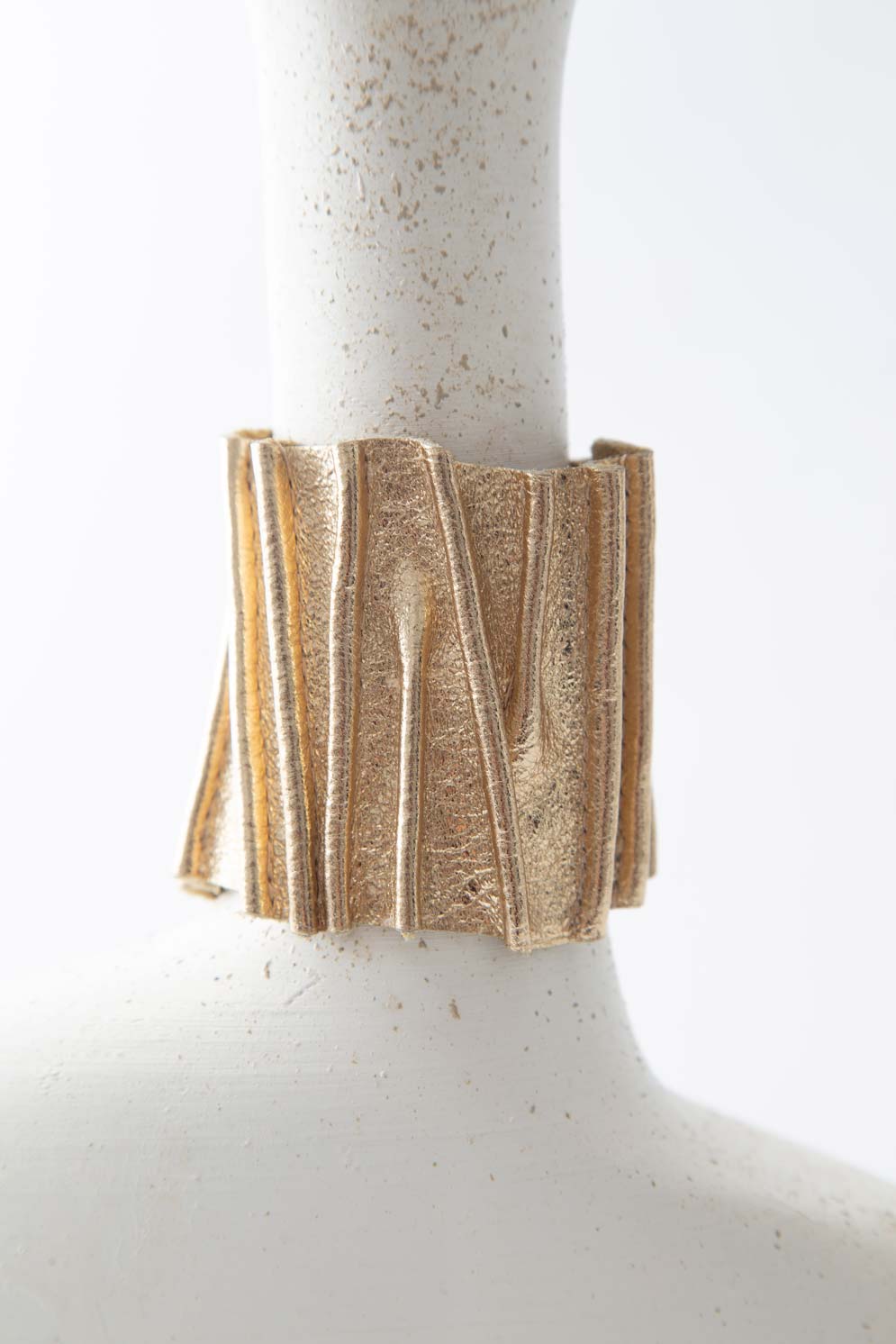 Bauhaus Stitch Bracelet by Iskin Sisters in gold metallic acrylic and soft suede, Argentina