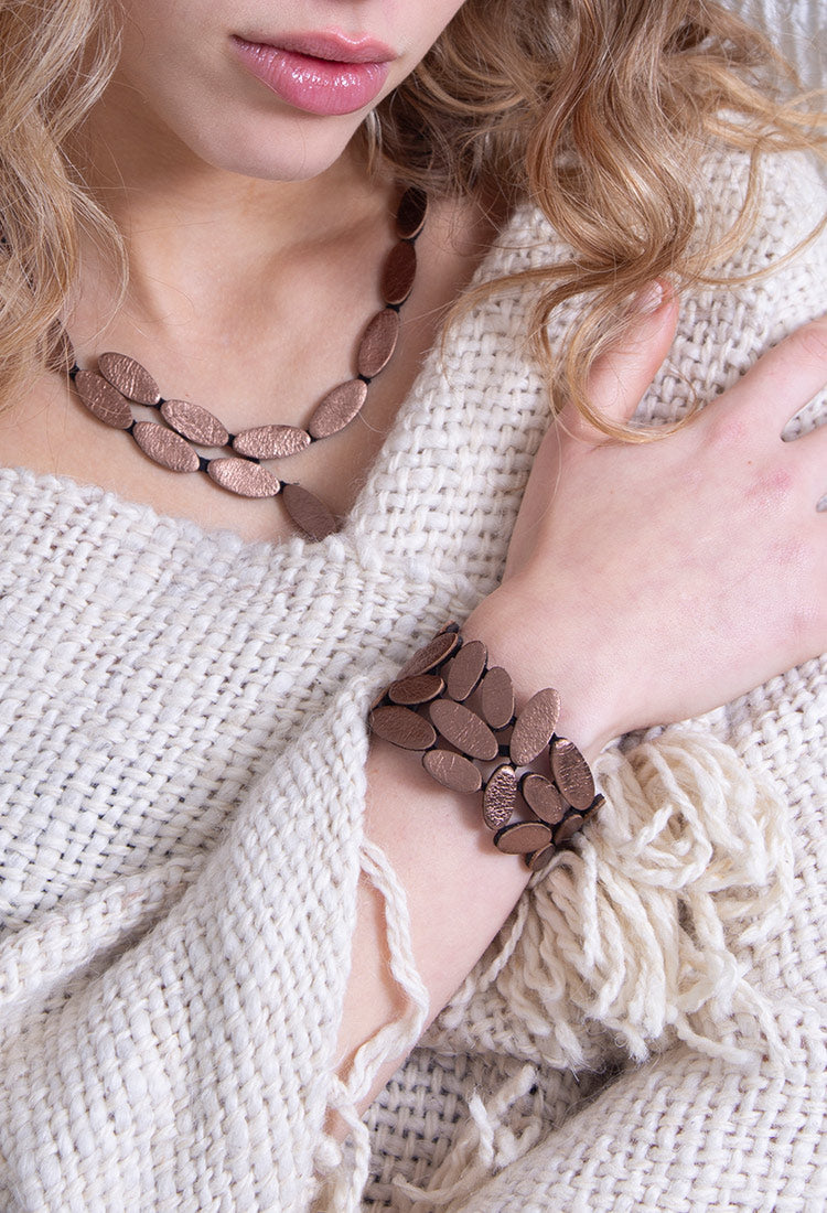 Emma Bracelet in brown/bronze leather featuring a sculptural organic design on a model, worn with the Emma Y Necklace. Contemporary Jewelry. Wearable art.