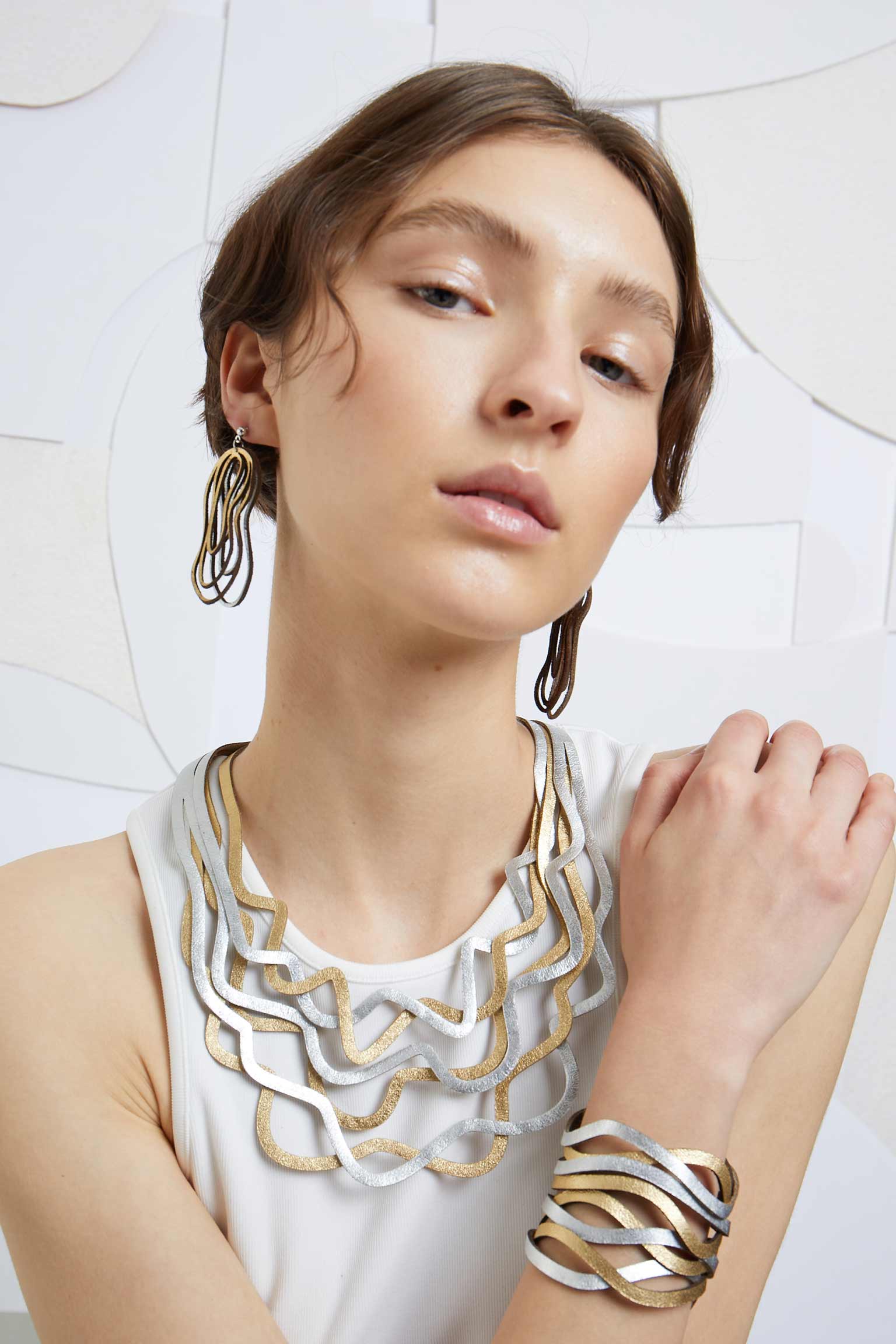 Statement leather cuff bracelet with snap closure in silver and gold by Iskin Sisters, Buenos Aires