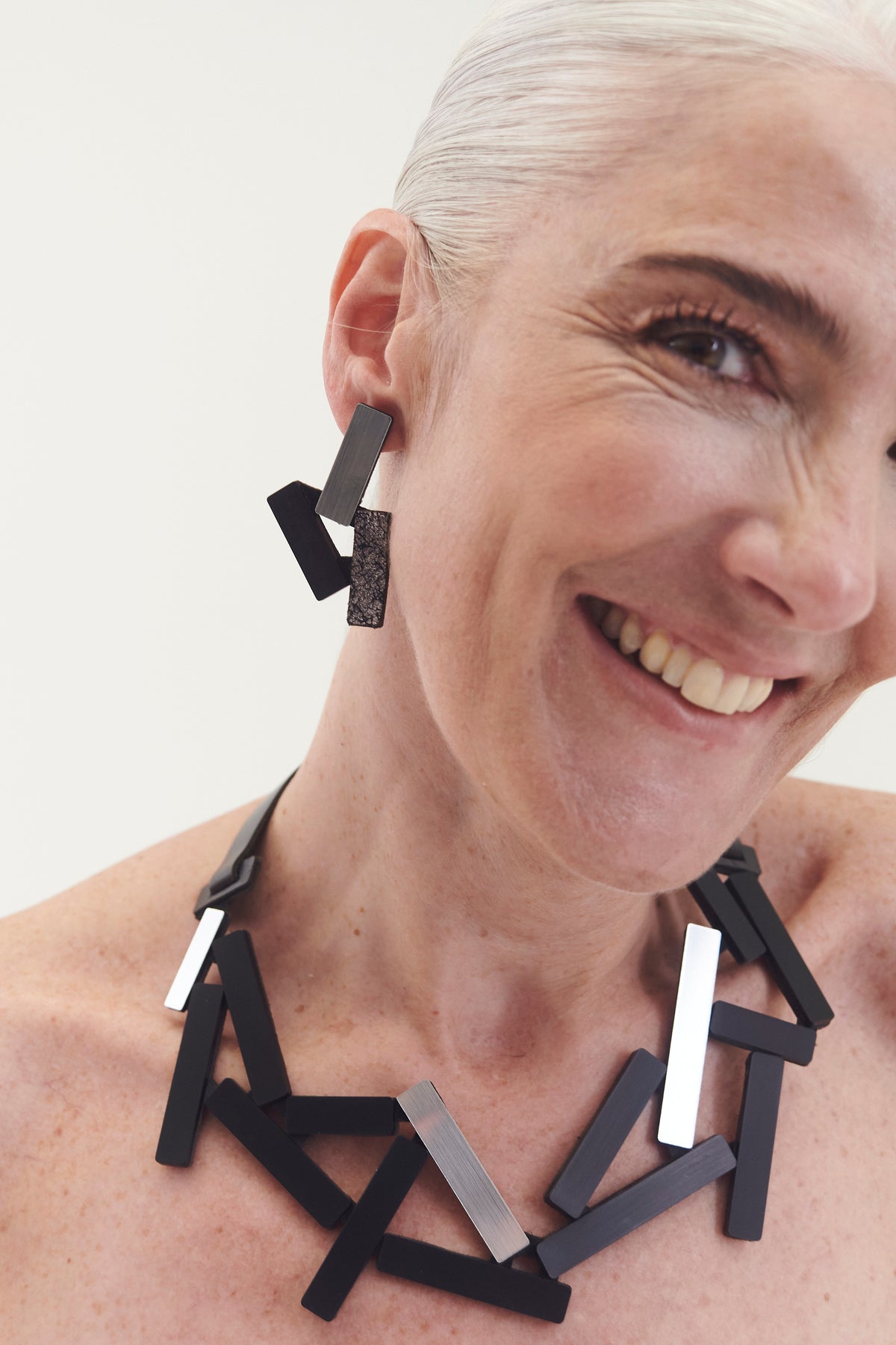 Ray Necklace Large by Iskin Sisters in silver and black metallic acrylic with hand-cut leather