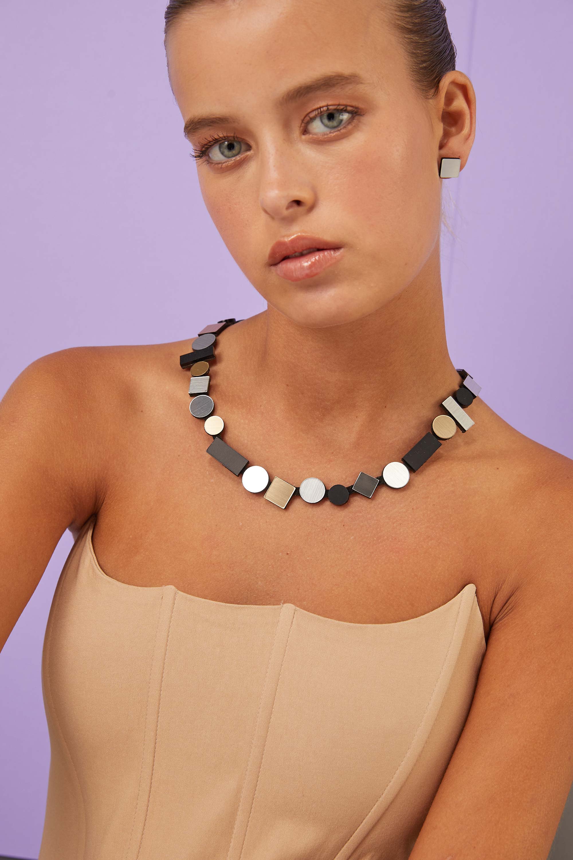 Statement round necklace in metallic acrylic and suede by Iskin Sisters, made in Buenos Aires
