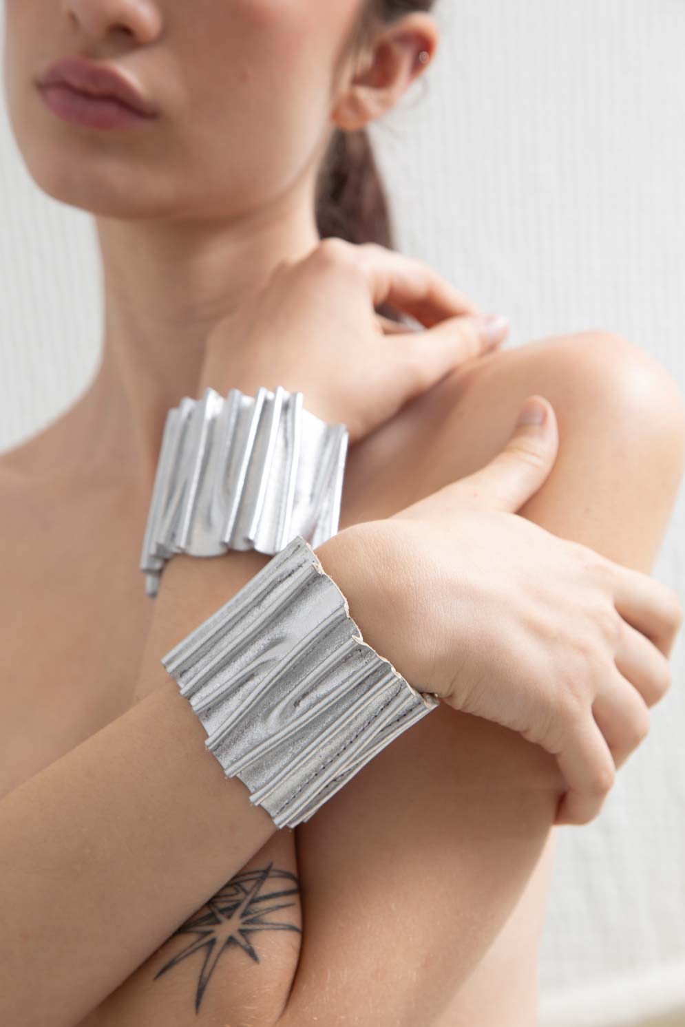 Bauhaus Stitch Bracelet by Iskin Sisters in silver metallic acrylic and soft suede, Argentina