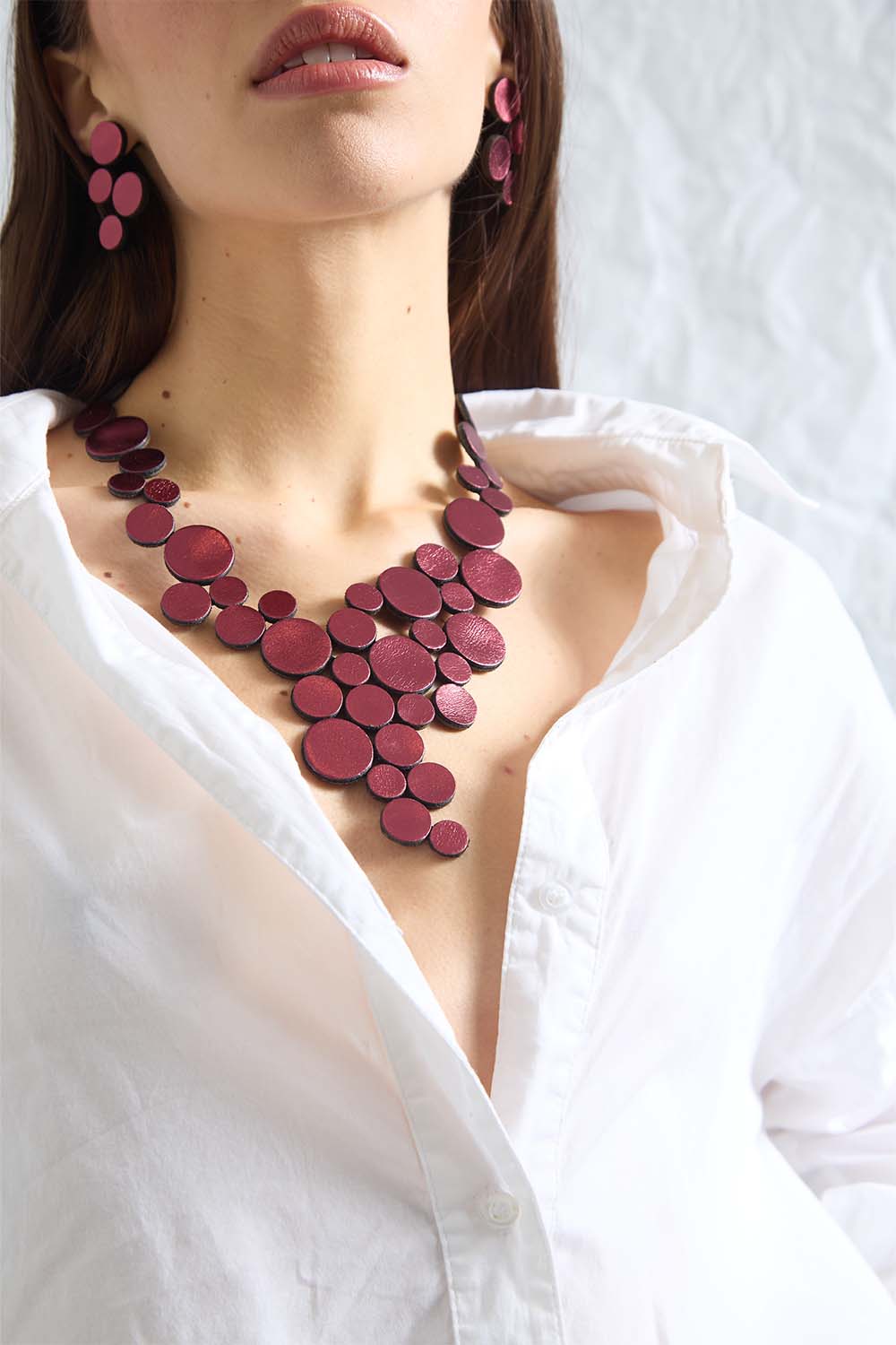 Sculptural circles in burgundy leather, Abstraction collection necklace by Iskin Sisters