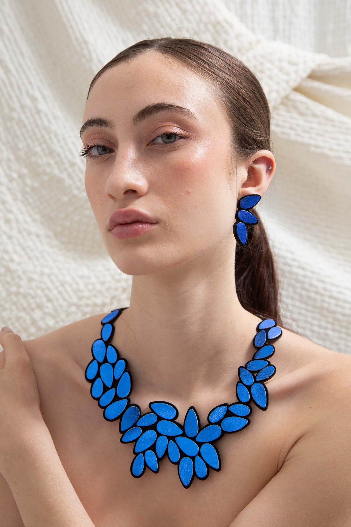 Blue leather drop-shaped statement earrings from the Raindrop collection, handmade by Iskin Sisters